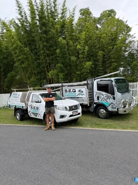 SEQ Plumbing and Roofing service vehicles at residential job site
